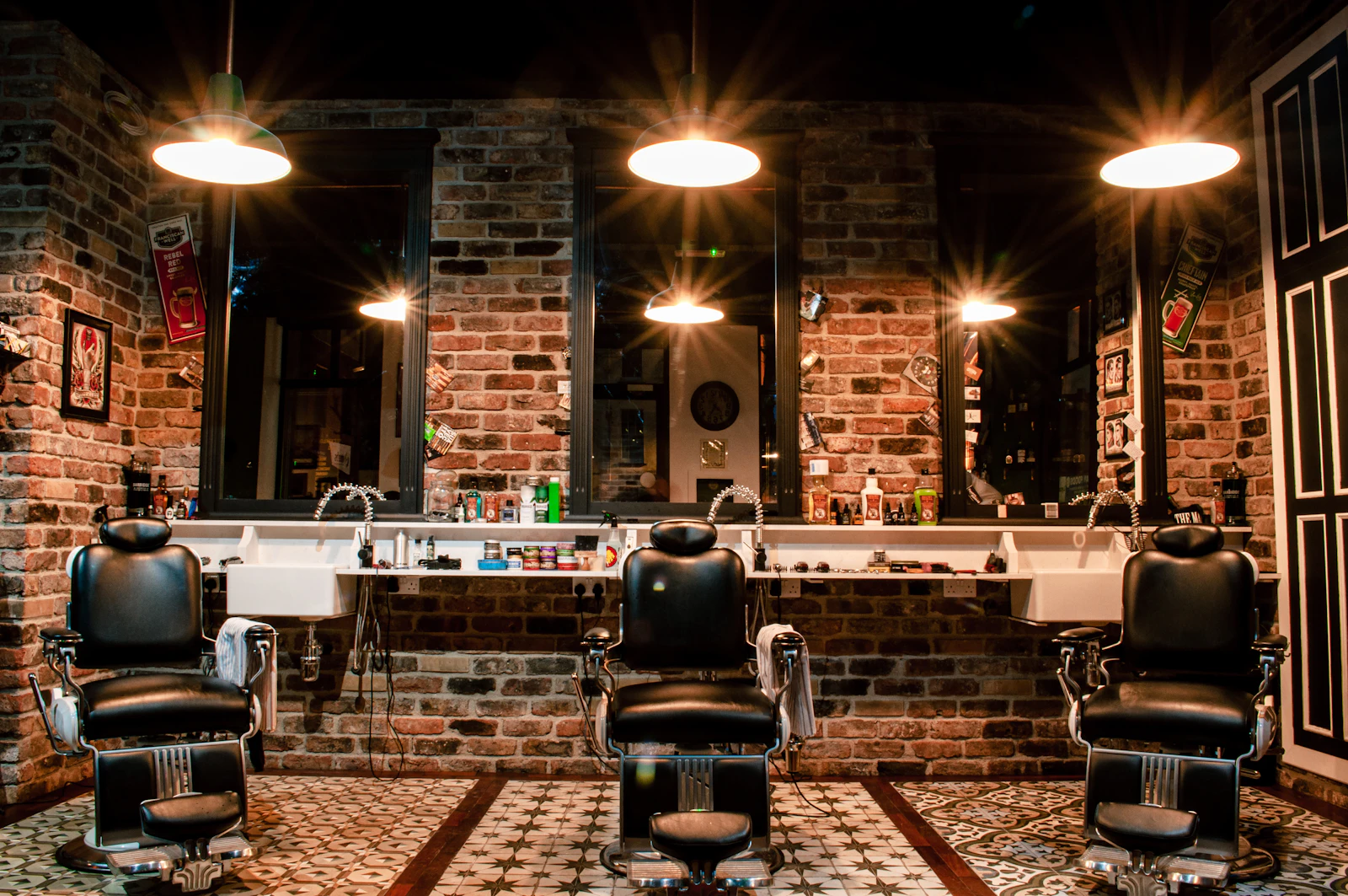 Leather barber chairs against a warm brick wall