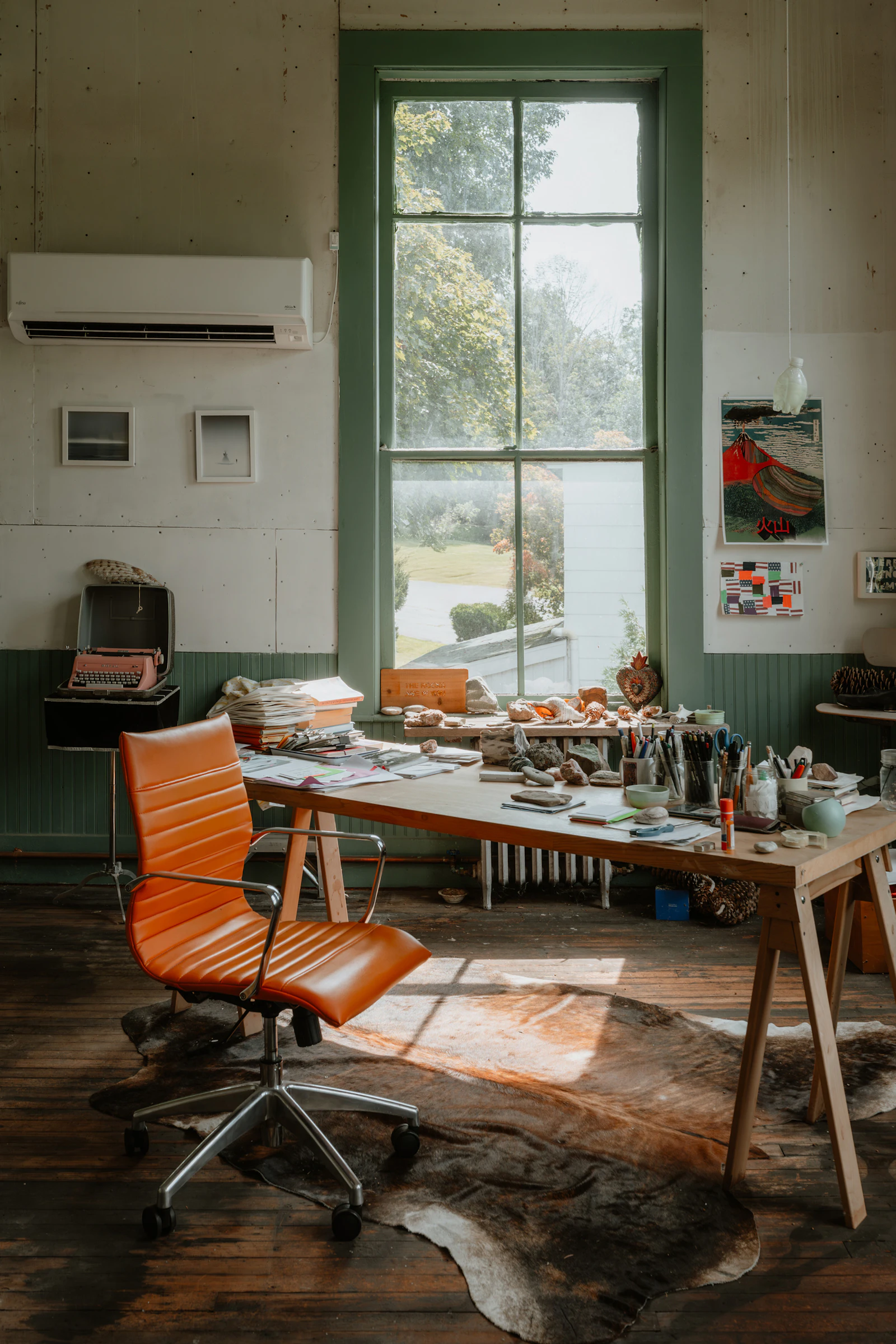 Sunlit creative workspace with an orange chair